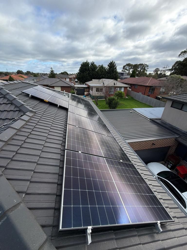 Solar panels across two faces of a tiled roof in a suburban street